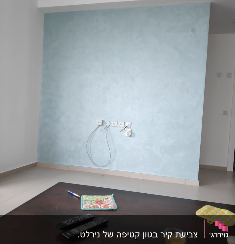 קיר צבוע בגוון כחול בהיר עם טקסטורה